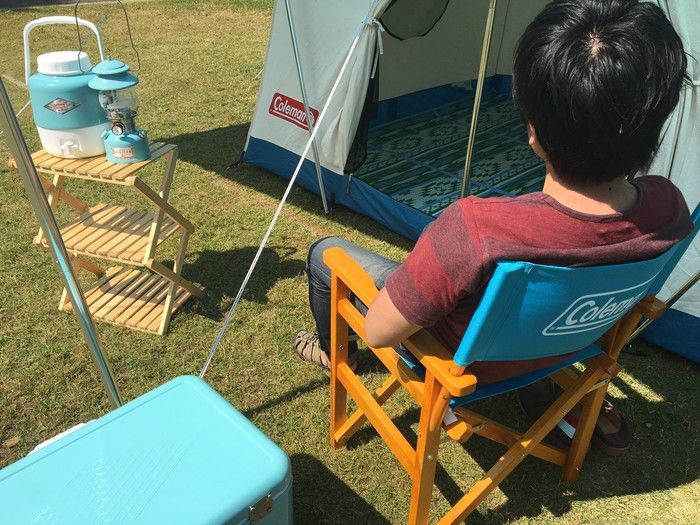 ヴィンテージシリーズの椅子に座る人とキャンプグッズ