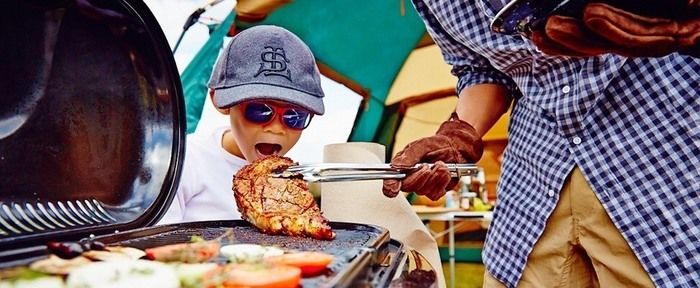 バーベキューでお肉にかぶりつこうとする子供
