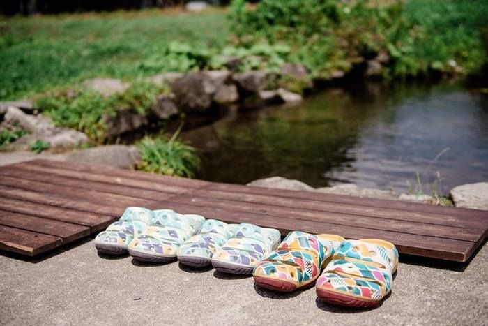 池のほとりに並べられたKEENのサンダル