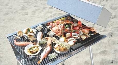 バーベキューコンロを用いて焼かれている魚介類