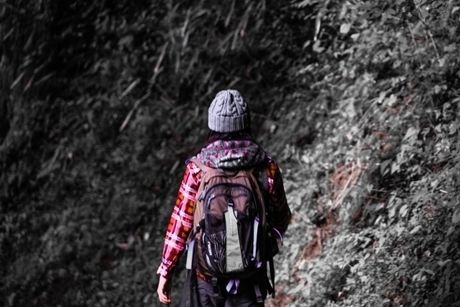 岩肌に向かって歩く女性の後ろ姿