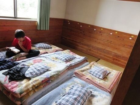 西穂高岳の山荘の寝室で本を読む子供