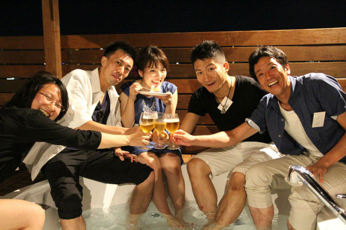 足湯でビールを飲む人々