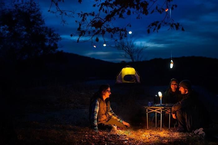 夜の山でテントを張って語り合う人々