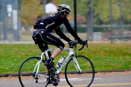 サコッシュバッグを下げ、自転車に乗る男性