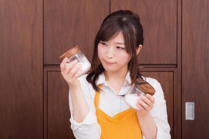 調味料の瓶をもつ女性