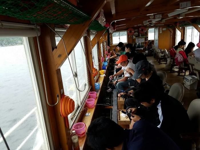 ワカサギ釣りのドーム船で釣りをする人々