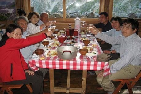 山小屋で大人数で食事をする様子
