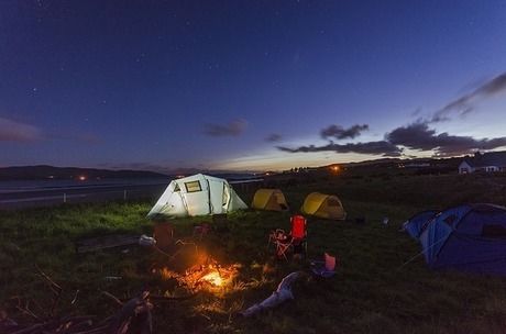 夕暮れ時にたき火を囲む人々