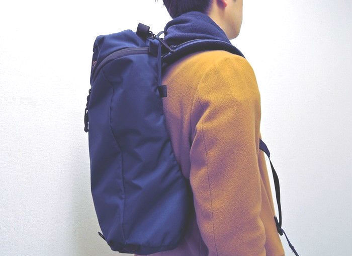 リュックを背負い横を向く男性