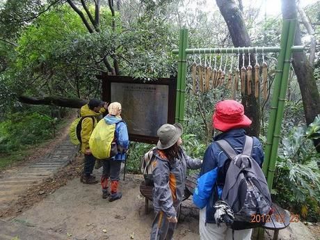山道の標識や建造物に目を向ける人