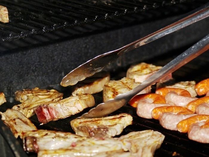 グリルで焼かれる肉と肉をつかむトング