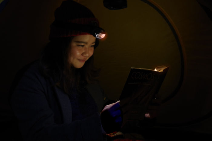 ヘッドライトをつけて本を読む女性