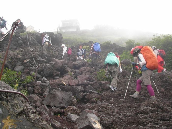山の岩肌を列になって登る人々