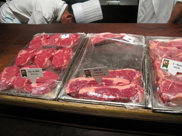銀のお皿にのせられた肉の塊とシェフ