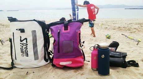 砂浜に置かれたストリームトレイルのバッグと水筒