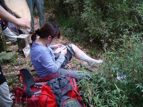 登山道で休憩する女性