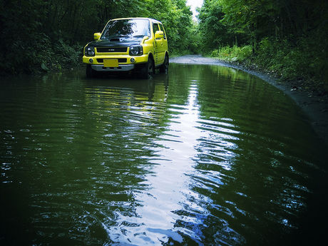 水たまりを走る軽自動車
