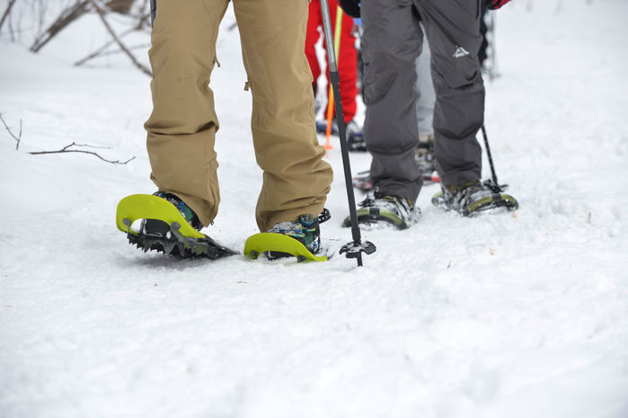 KEENのスノーシューズを履いて雪山を歩く人々の足元