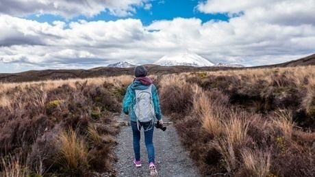一本道を歩く女性の後ろ姿