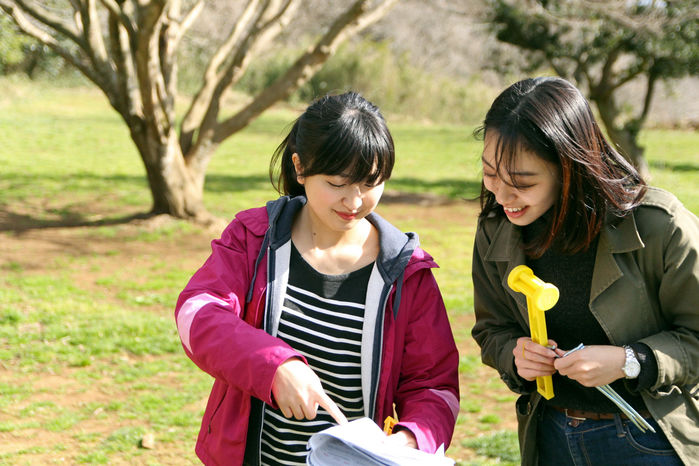 ペグを持ち楽しそうに説明書を見ている女性2人