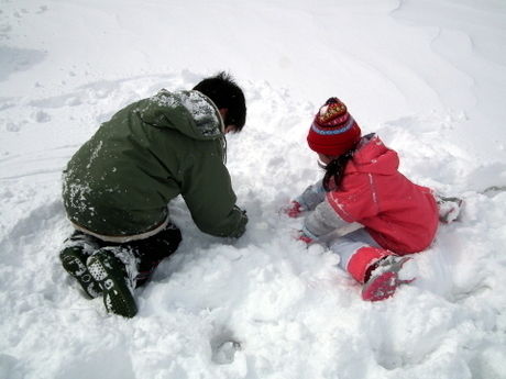 酸ヶ湯公共駐車場で雪遊びをする子供