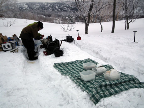 雪製ピクニックテーブルの隣で調理する様子