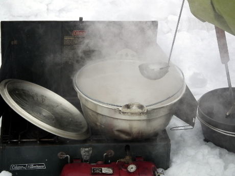 雪原の中で料理する様子