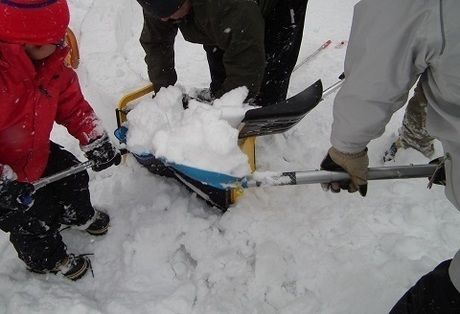 スノーショベルで雪を集める様子