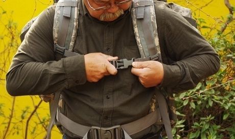 バックパックのチェストストラップをしめる男性