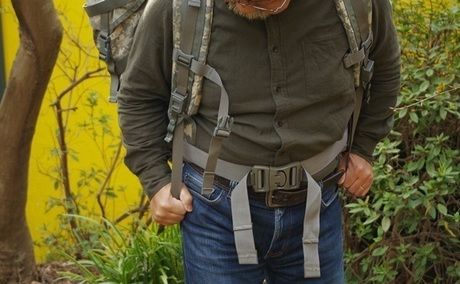 バックパックのショルダーパッドのストラップをしめる男性