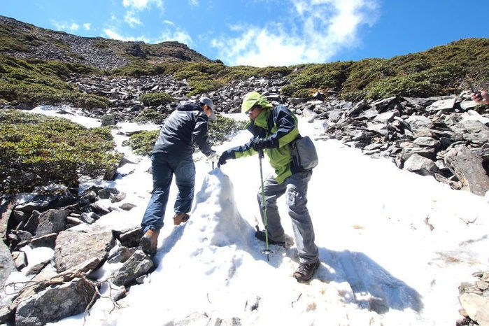 幸が積もった山を登る男性