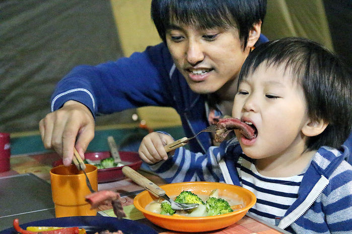 キャンプで食事を楽しむ親子