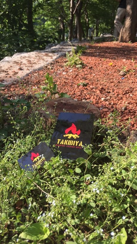 外の草むらに置かれたTAKIBIYAの看板