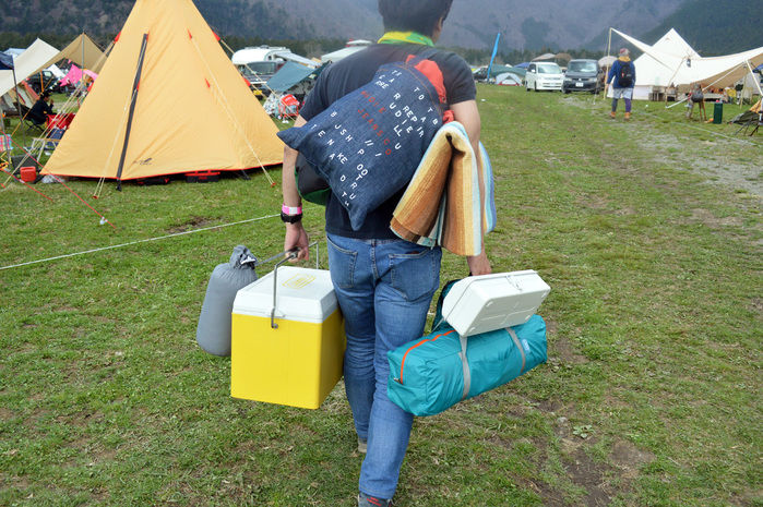 両手に大荷物を抱える男性
