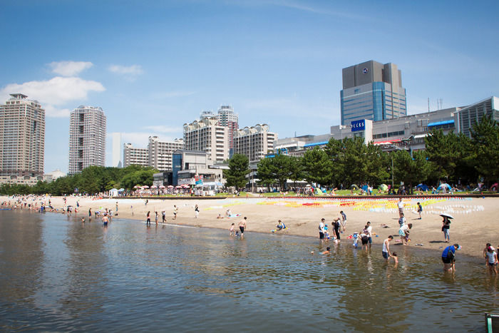 お台場海浜公園の海辺で遊ぶ人たち