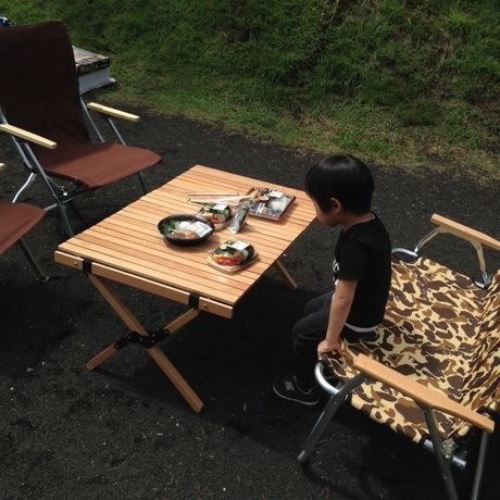 外でお弁当を食べる少年