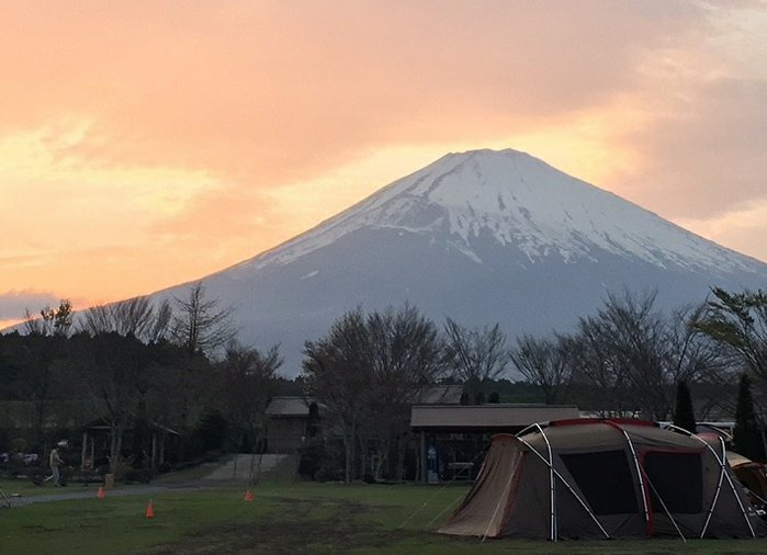 夕日に照らされる富士山の下に張られたテント