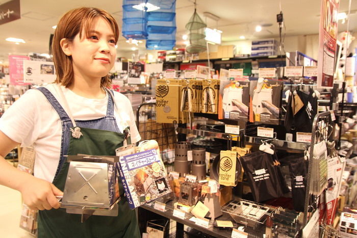 焚き火台を持つ店員さん