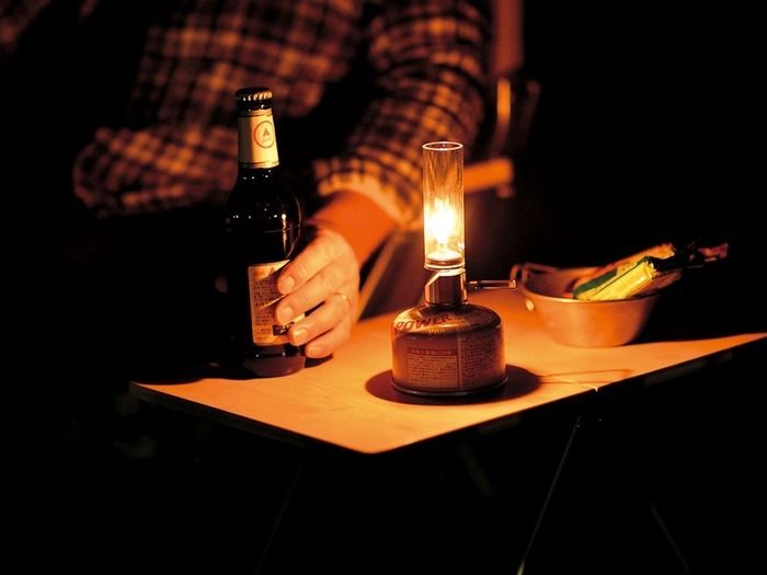 スノーピークのランタンとお酒を持った男性