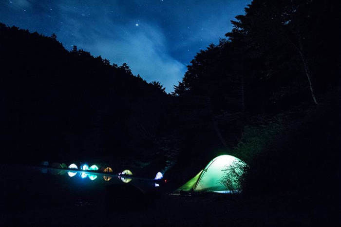 長野県北八ヶ岳の双子池キャンプ場での星空の下、テントが光る様子
