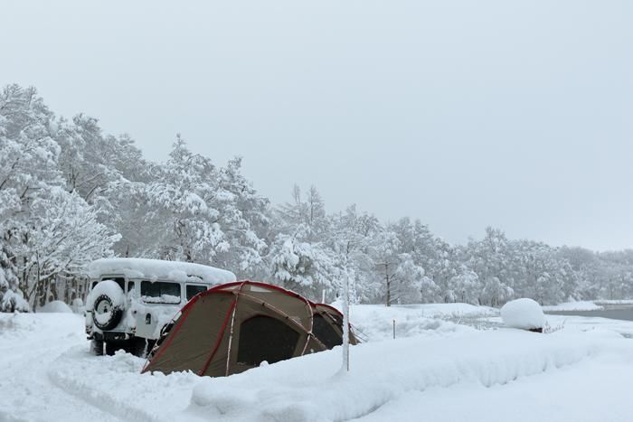 雪の中のテントとキャンピングカー