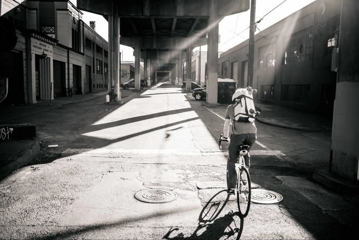 自転車に乗り背負っている様子