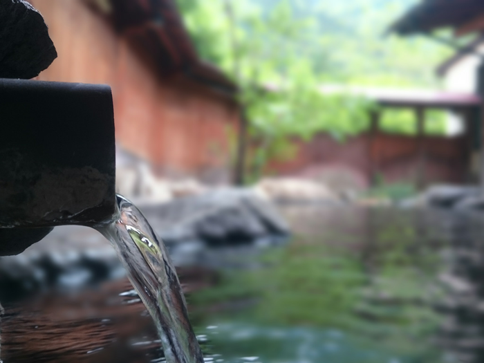 温泉で湯が注がれている様子