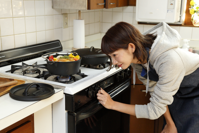 料理の火加減を見る女性