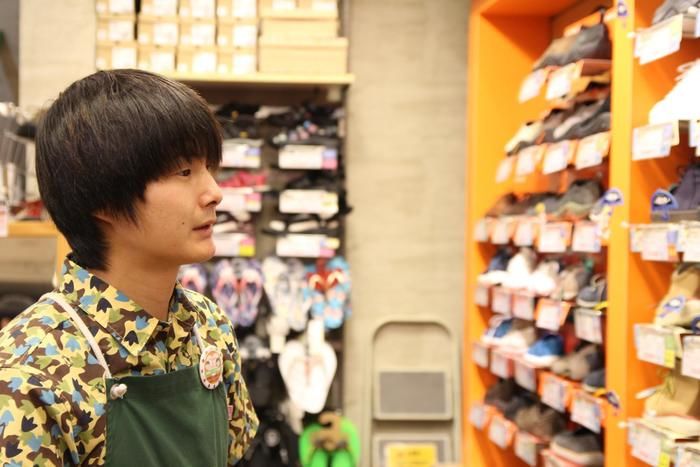 靴の棚を眺める佐藤さん