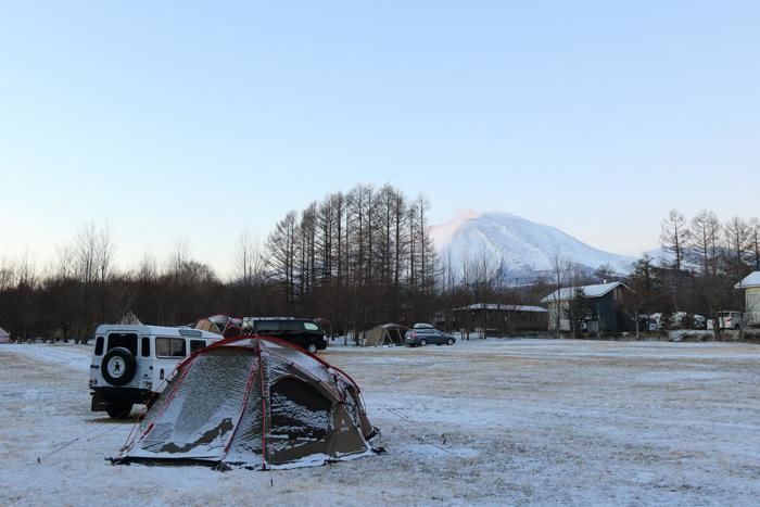 雪の残るキャンプ場とテント