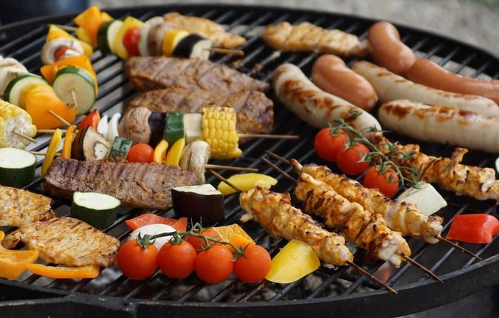 肉や野菜をバーベキュー網で焼いている様子