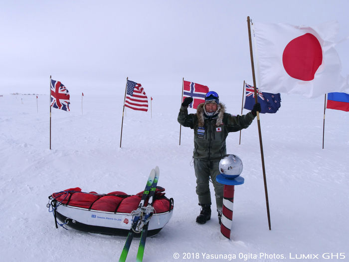 南極で日本の国旗を掲げる荻田泰永さん