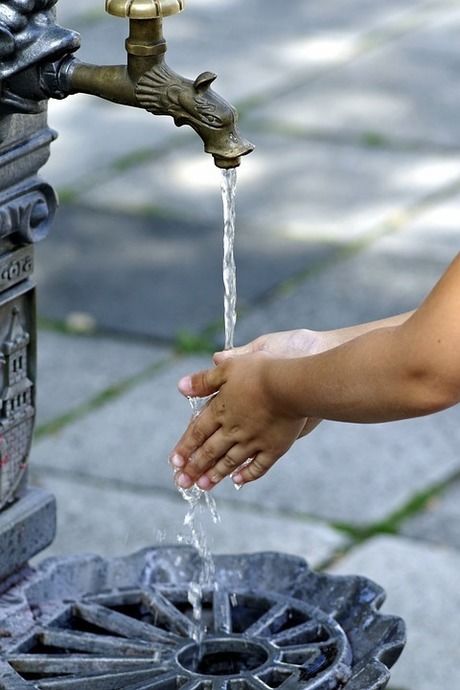 水道で手を洗っている人